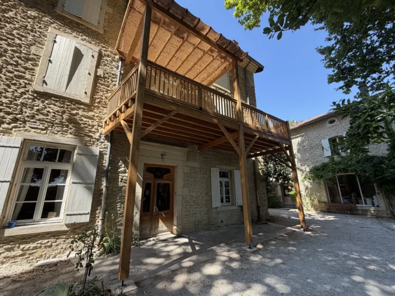 Pergola bois balcon batisse pierre angle